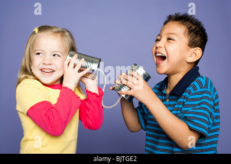 Kleine Jungen und Mädchen mit Blechdosen und string Stockfoto