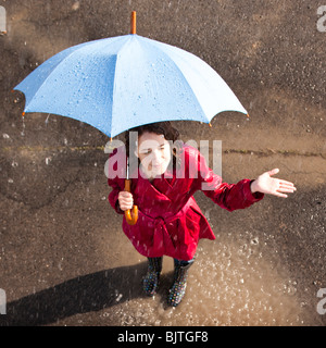 Junge Frau im Regen mit Regenschirm Stockfoto