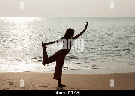 Frau praktizieren Yoga ja Sonnenuntergang Meer Stockfoto