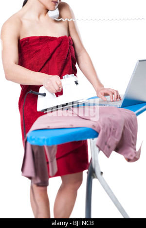 Frau, ein Bügeleisen/-Brett und arbeiten am laptop Stockfoto