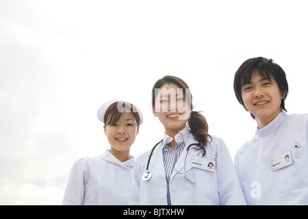 Arzt und Krankenschwestern in die Kamera lächeln Stockfoto