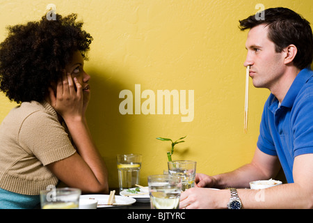 Mann mit Stäbchen in Nase im restaurant Stockfoto