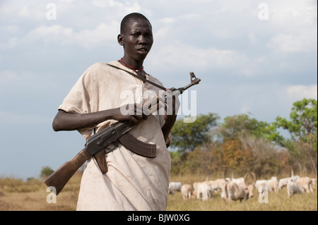 Süd-SUDAN, Cuibet in der Nähe von Rumbek, Dinka Stamm, Schäfer, bewaffnet mit Kalaschnikow AK-47 schützen ihre Zebu-Kühe aus feindlichen Rinder Raider Stockfoto