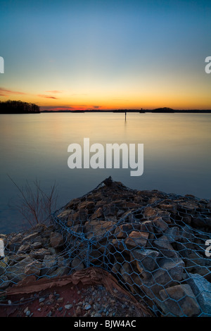 Dies ist ein Sonnenuntergang Bild, aufgenommen im alten Bund Park am östlichen Ufer des Lake Lanier in der Nähe von Flowery Branch, GA.  Der konkrete Anker im Bild wird verwendet, um ein Ende einer Schnur von Bojen ankern, die aus den Schwimmbereich zu markieren. Stockfoto