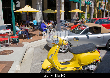 Menschen Essen in Outdoor-Straßencafé mit geparkten gelb Roller auf der Main Street in Sarasota Florida Stockfoto