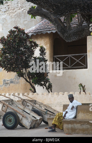 Ein Mann sitzt in der Hauptansicht von lamu Platz vor dem alten Fort, nördlichen Kenia, Afrika Stockfoto