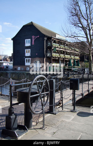 Rad-Mechanismus für den Betrieb von anhebende Fußgängerbrücke und Dickens Inn Pub, St Katharine Dock, London Stockfoto