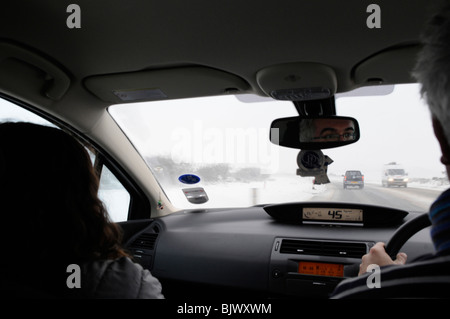 Verräterische Fahrbedingungen auf der A303 als starker Schneefall und icey Bedingungen getroffen Großbritannien. Fahren im Schnee auf der Autobahn. Stockfoto