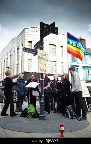 "Cor Gobiath / Choir of Hope"-eine Gruppe von Frauen Frieden Aktivisten auf der Straße, Aberystwyth Wales UK singen Stockfoto