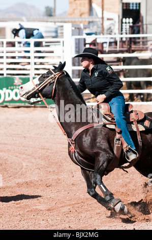 eine Cowgirl konkurriert in das Faßlaufen Ereignis bei einem rodeo Stockfoto