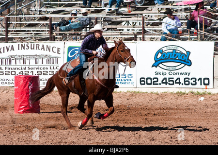 eine Cowgirl konkurriert in das Faßlaufen Ereignis bei einem rodeo Stockfoto