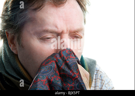 Kaukasischen Mann Nase in seidenes Taschentuch vor weißem Hintergrund Stockfoto