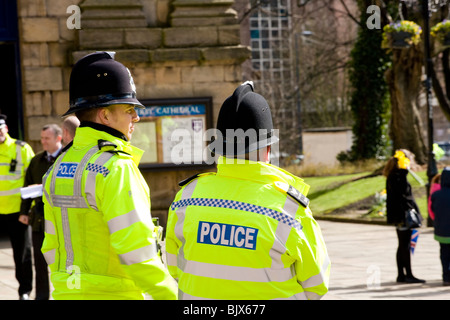Zwei Polizisten bewachen um die Menschenmenge vor Derby Kathedrale während The Queens für Gründonnerstag Ostern besuchen zu sehen. Stockfoto