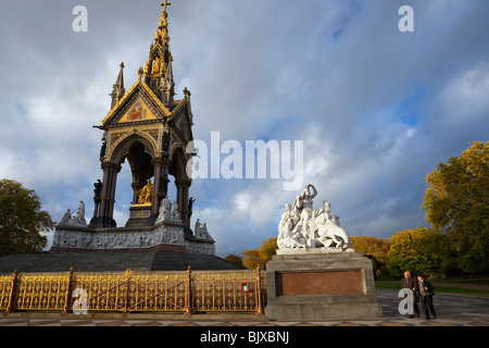 Paar Fuß in die Abendsonne hinter Royal Albert Memorial Hyde Park im Herbst London England Großbritannien Vereinigtes Königreich UK GB Stockfoto