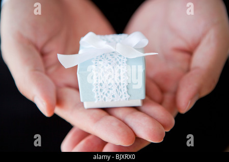 Junger Mann hält ein Geschenk Stockfoto