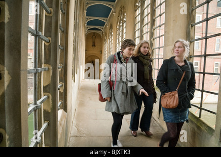 Drei Studentinnen, die Überquerung der Seufzerbrücke, St Johns College, Universität Cambridge, Cambridge, UK Stockfoto