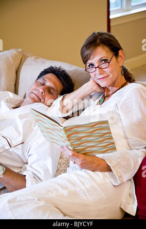 Paar mittleren Alters lesen und Faulenzen am Sofa zu Hause Stockfoto