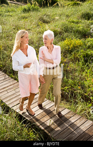 Mutter und Tochter spazieren hand in Hand auf Promenade Stockfoto