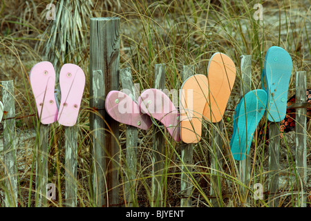 Flip-Flops oder Sandalen auf einem Zaun an einem Strand in Florida USA Stockfoto