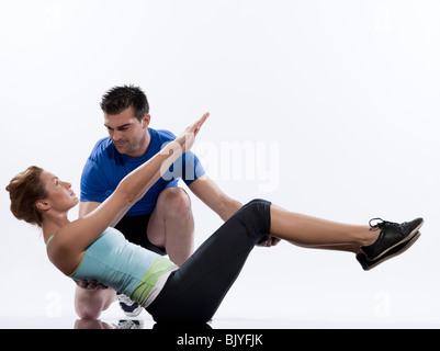 ein kaukasischer paar Mann aerobic Trainer Positionierung Frau Training Trainer Haltung Innenräumen Studio isoliert auf weißem Hintergrund Stockfoto