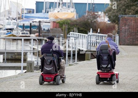 Zwei Männer im motorisierten Rollstuhl am Kai von Lymington. Stockfoto