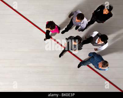 Geschäftsleute, die über eine rote Linie Stockfoto