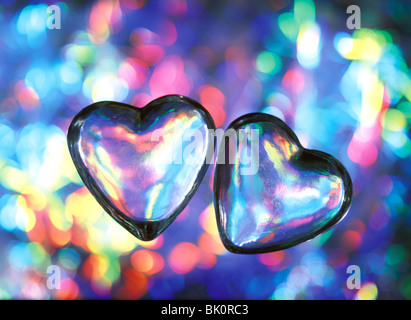 Zwei transparente Glas-Herzen auf bunten Hintergrund Stockfoto