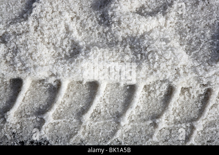 Salz Textur mit LKW-Fußabdruck Straße Eis Hintergrund Stockfoto