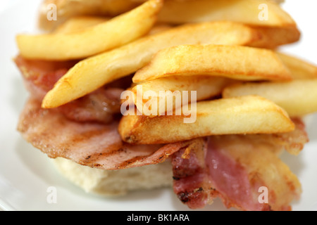 Ein frisch zubereitetes, gegrilltem oder gebratenem Speck in einem weißen Brötchen oder Bap mit einer Seite der Kartoffelchips oder Pommes Frites mit Keine Personen Stockfoto