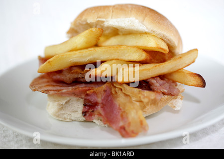 Ein frisch zubereitetes, gegrilltem oder gebratenem Speck in einem weißen Brötchen oder Bap mit einer Seite der Kartoffelchips oder Pommes Frites mit Keine Personen Stockfoto