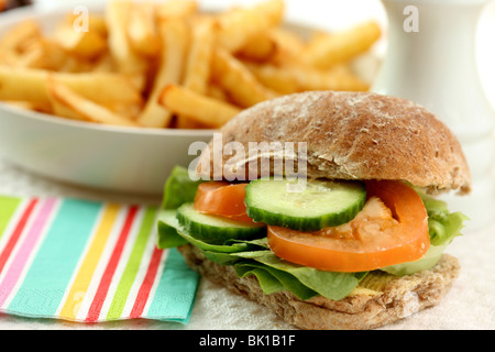 Frisch zubereitete Gesunde vegetarische Vollkorn Salat mit frischen Tomaten und Gurken und einen Teller Chips oder Pommes Frites und keine Leute in Scheiben geschnitten Stockfoto