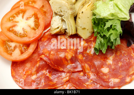 Frisch zubereitete italienische Mediterrane Salami Wurst mit Antipasto und Salat mit Artischocken Tomaten und grünen Salat keine Menschen Blätter Stockfoto