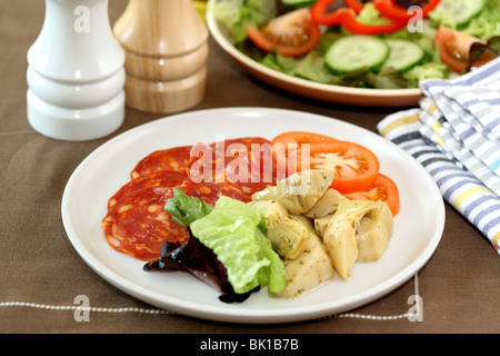 Frisch zubereitete italienische Mediterrane Salami Wurst mit Antipasto und Salat mit Artischocken Tomaten und grünen Salat keine Menschen Blätter Stockfoto