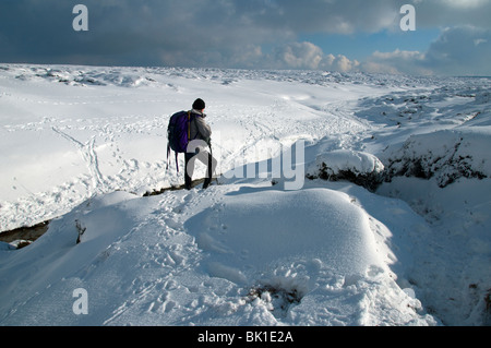 Eine Gehhilfe vor Kinder Toren auf dem Kinder Scout-Plateau im Winter, in der Nähe von Hayfield, Peak District, Derbyshire, England, UK Stockfoto