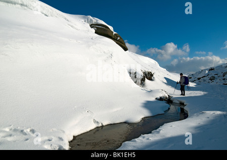 Eine Gehhilfe vor Kinder Toren auf dem Kinder Scout-Plateau im Winter, in der Nähe von Hayfield, Peak District, Derbyshire, England, UK Stockfoto