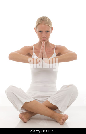 Kaukasische Mädchen gekleidet in weißen sitzen im Schneidersitz, Yoga machen Stockfoto