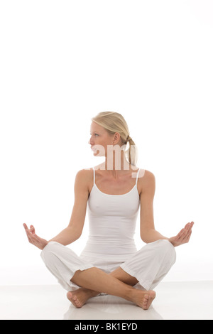 Kaukasische Mädchen gekleidet in weißen sitzen im Schneidersitz, Yoga machen Stockfoto