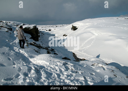 Eine Gehhilfe vor Kinder Toren auf dem Kinder Scout-Plateau im Winter, in der Nähe von Hayfield, Peak District, Derbyshire, England, UK Stockfoto