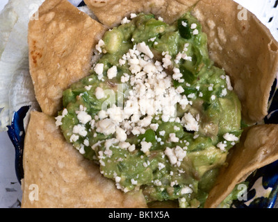 Guacamole Vorspeise mit frischem weißem Käse bestreut & beringt mit Tortilla-Chips in Mexiko-Stadt Restaurants Stockfoto