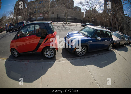 Ein zweisitziger Smart Auto, links, Fabrikat Daimler und einen Mini Cooper sind gepresste in eine Parklücke in New York gesehen Stockfoto