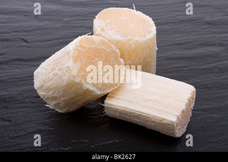 Stücke von rohem Zuckerrohr dunklen Schiefer Hintergrund. Stockfoto