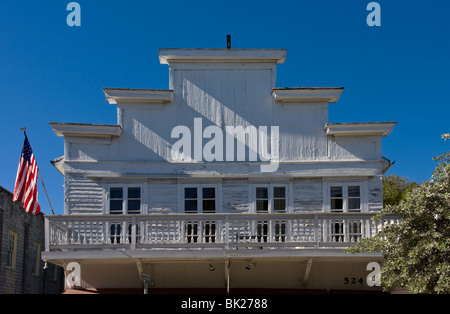 Klassische Anwesen in Key West, obere Ebene und abgestufte Dachlinie. Holzrahmen und verkleidet mit Balkon. Duval Street, Florida, USA. Stockfoto