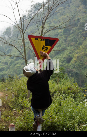 Man scherzt mit Kopf Warnung Zeichen entlang Route 34 zwischen Bao Lac und Cao Bang in Nord-Vietnam Stockfoto