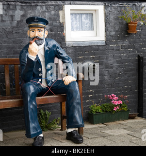 Statue des Matrosen sitzt auf einer Bank im Garten, Gartendekoration. Stockfoto