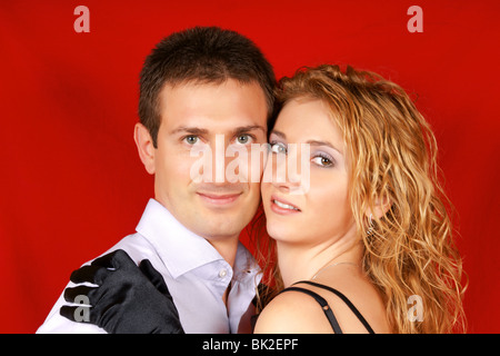 Schöne junge Paar in Liebe Blick in die Kamera über einen roten Hintergrund. Soft-Fokus. Stockfoto