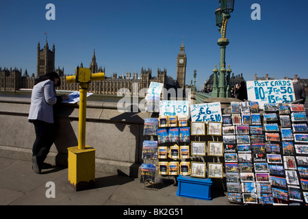 Big Ben inmitten der gotischen Architektur der britischen Houses of Parliament und touristische Postkarten angezeigt auf dem Damm Stockfoto