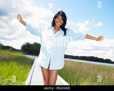 Frau Arme ausgebreitet, Lächeln Stockfoto