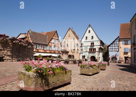 Blumenkübel auf dem Place du Chateau Square in mittelalterlichen Dorf an der Weinstraße, Eguisheim, Elsass, Haut Rhin, Frankreich Stockfoto