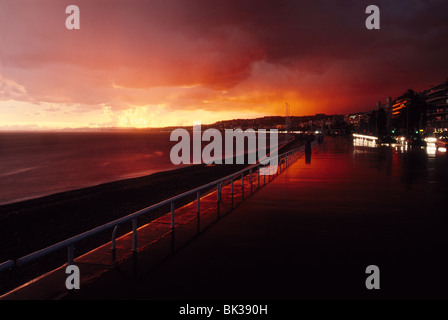 Stürmisches Wetter mit roter Himmel Sonnenuntergang auf der Promenade des Anglais, Nizza Stockfoto