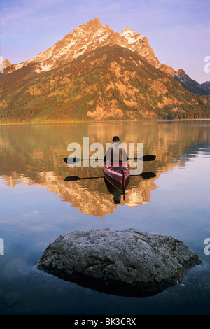 Kajakfahren auf Jenny Lake bei Sonnenaufgang unter Teewinot Berg im Grand-Teton-Nationalpark, Wyoming Stockfoto